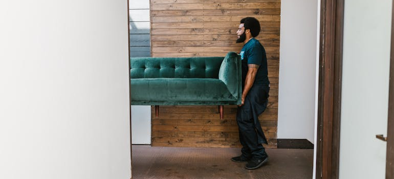 a man lifting a couch
