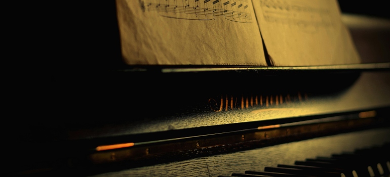 Dimly lit piano with vintage sheet music.