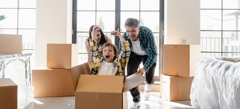 Parents watching their child play inside a box during move-in