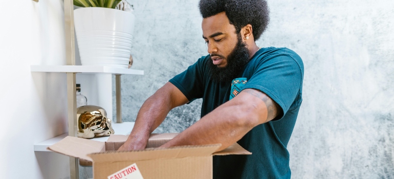 An employee of movers Salem VA packing a box.