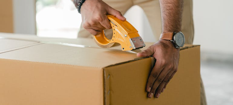 man taping a box