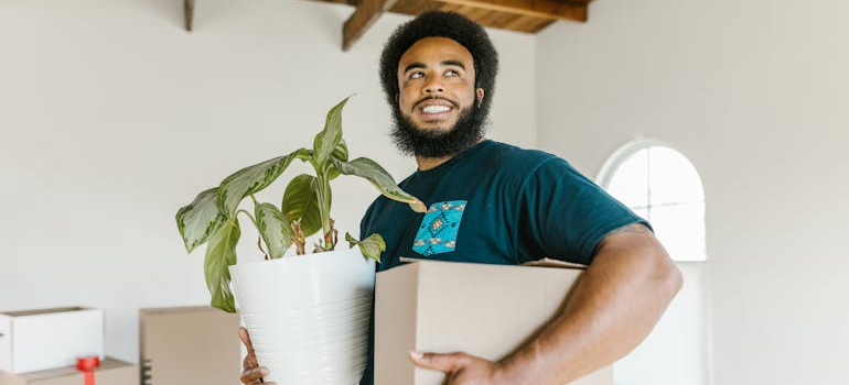 a mover holding a box and a pot