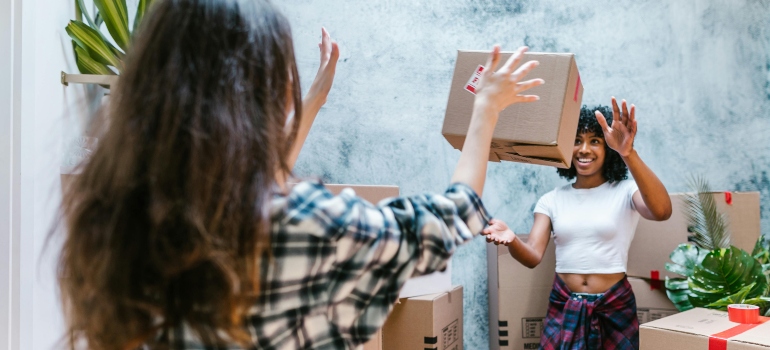 Two women are playing with a box.