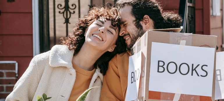 A happy couple holding a box.