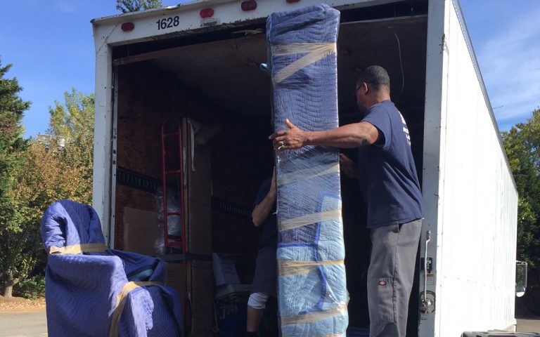 Ace Moving and Storage crew loading padded furniture into a moving truck